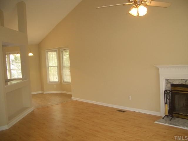 7301 Massachusetts Court Raleigh, NC 27615 - Photo 2 of 12 an empty room with windows and fireplace
