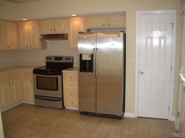 7301 Massachusetts Court Raleigh, NC 27615 - Photo 4 of 12 a kitchen with white cabinets and stainless steel appliances