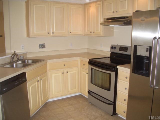 7301 Massachusetts Court Raleigh, NC 27615 - Photo 5 of 12 a kitchen with white cabinets and a stainless steel appliances