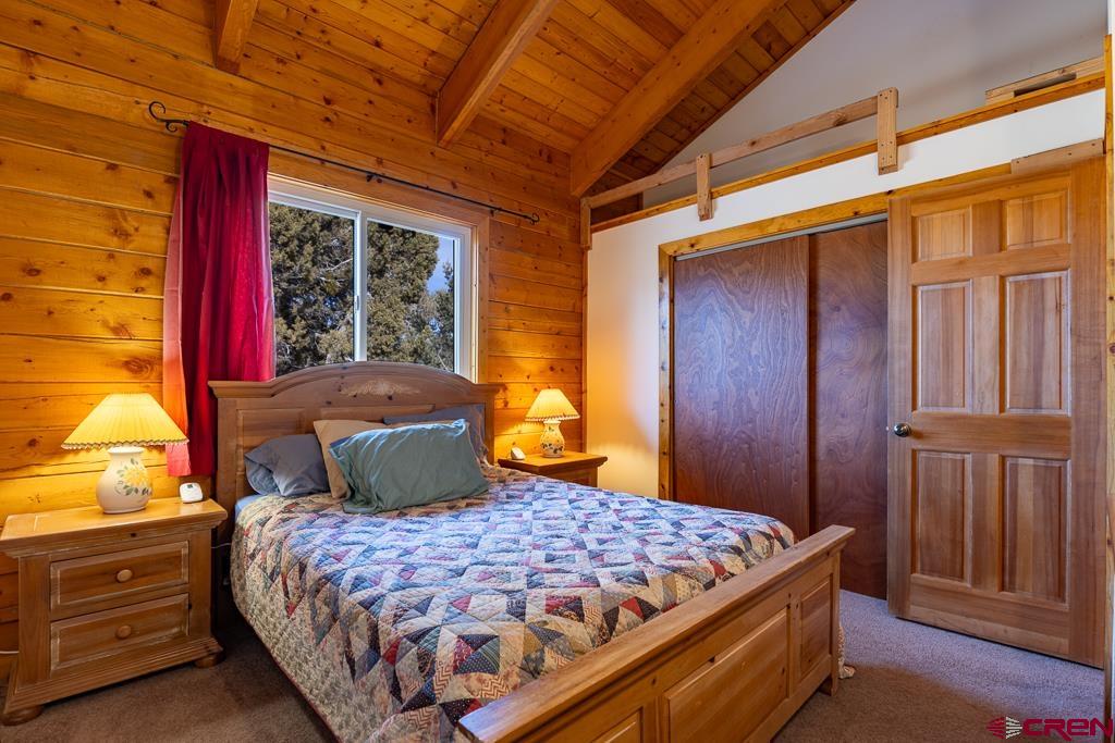 349 Mariposa Drive Durango, CO 81301 - Photo 17 of 34 a bedroom with a large bed and wooden floor