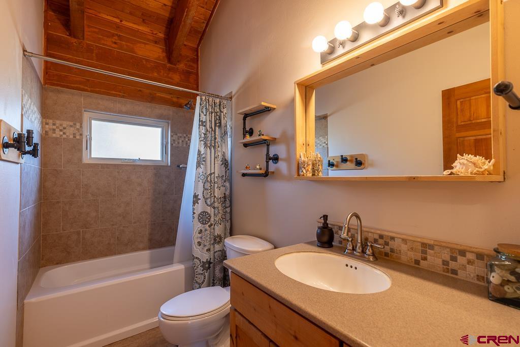 349 Mariposa Drive Durango, CO 81301 - Photo 19 of 34 a bathroom with a granite countertop sink toilet a mirror and bathtub
