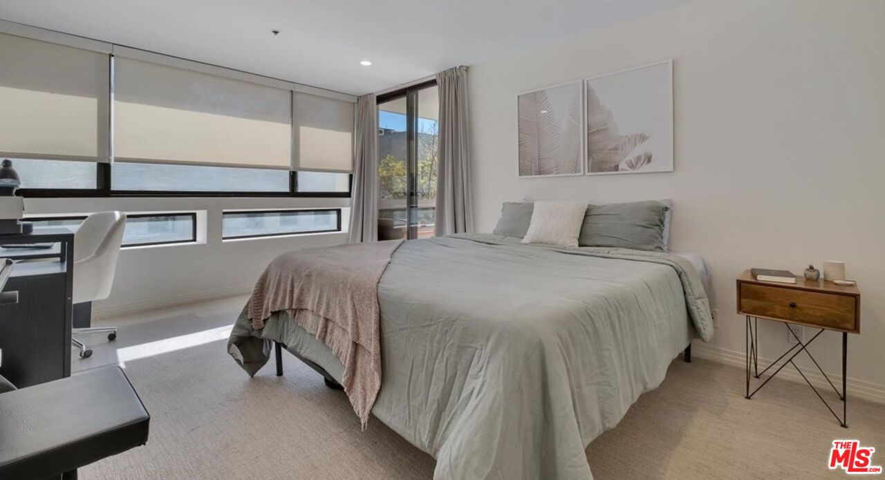 121 South Hope Street, Unit 313 Los Angeles, CA 90012 - Photo 13 of 35 a bedroom with a bed and dresser with mirror