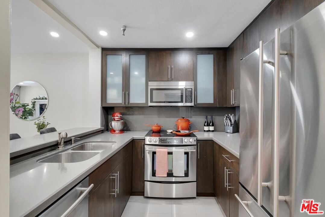 121 South Hope Street, Unit 313 Los Angeles, CA 90012 - Photo 5 of 35 a kitchen with stainless steel appliances granite countertop a sink stove and refrigerator
