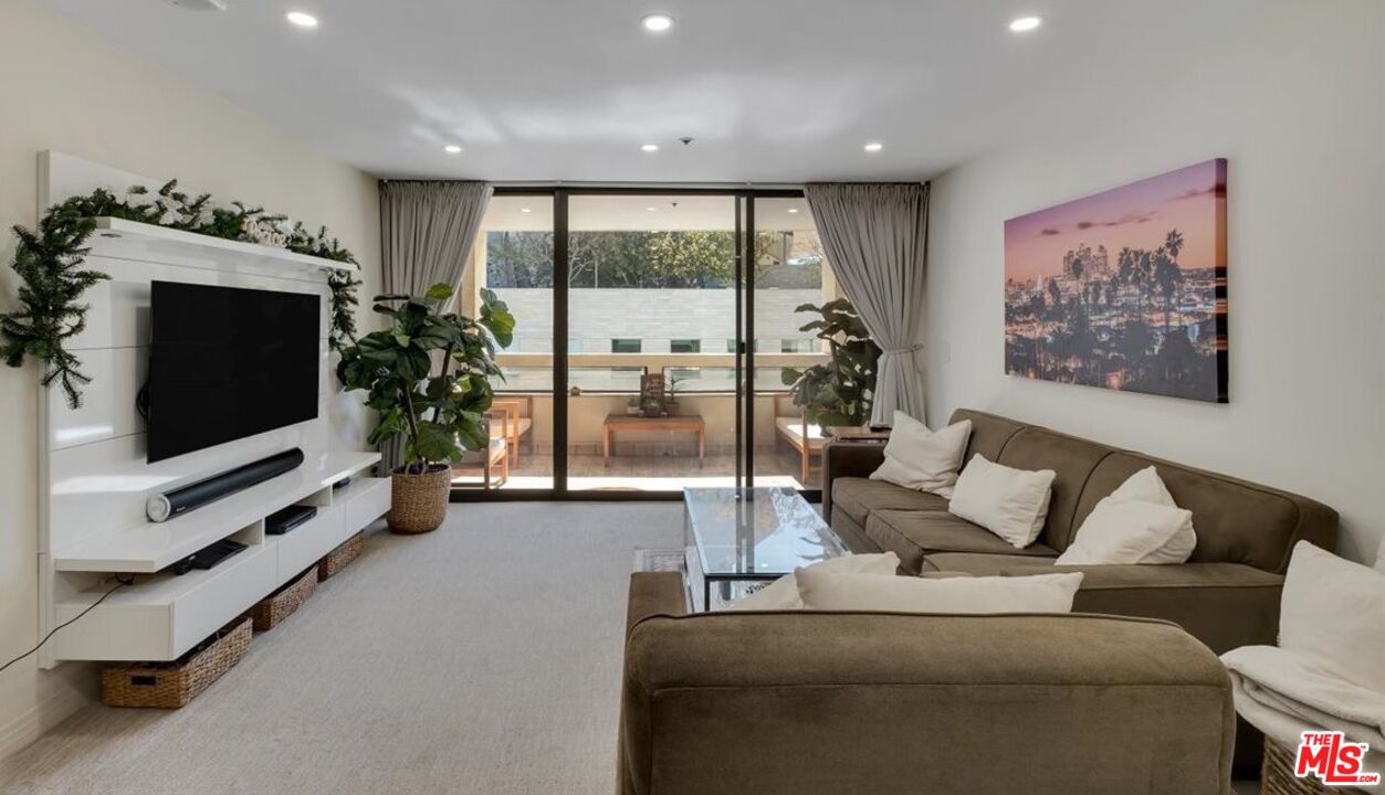 121 South Hope Street, Unit 313 Los Angeles, CA 90012 - Photo 9 of 35 a living room with furniture and a flat screen tv