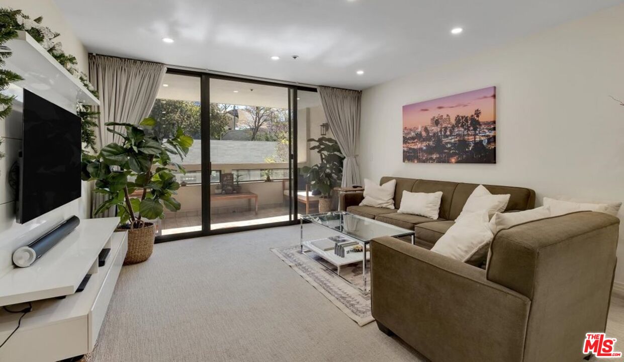 121 South Hope Street, Unit 313 Los Angeles, CA 90012 - Photo 10 of 35 a living room with furniture a flat screen tv and a large window