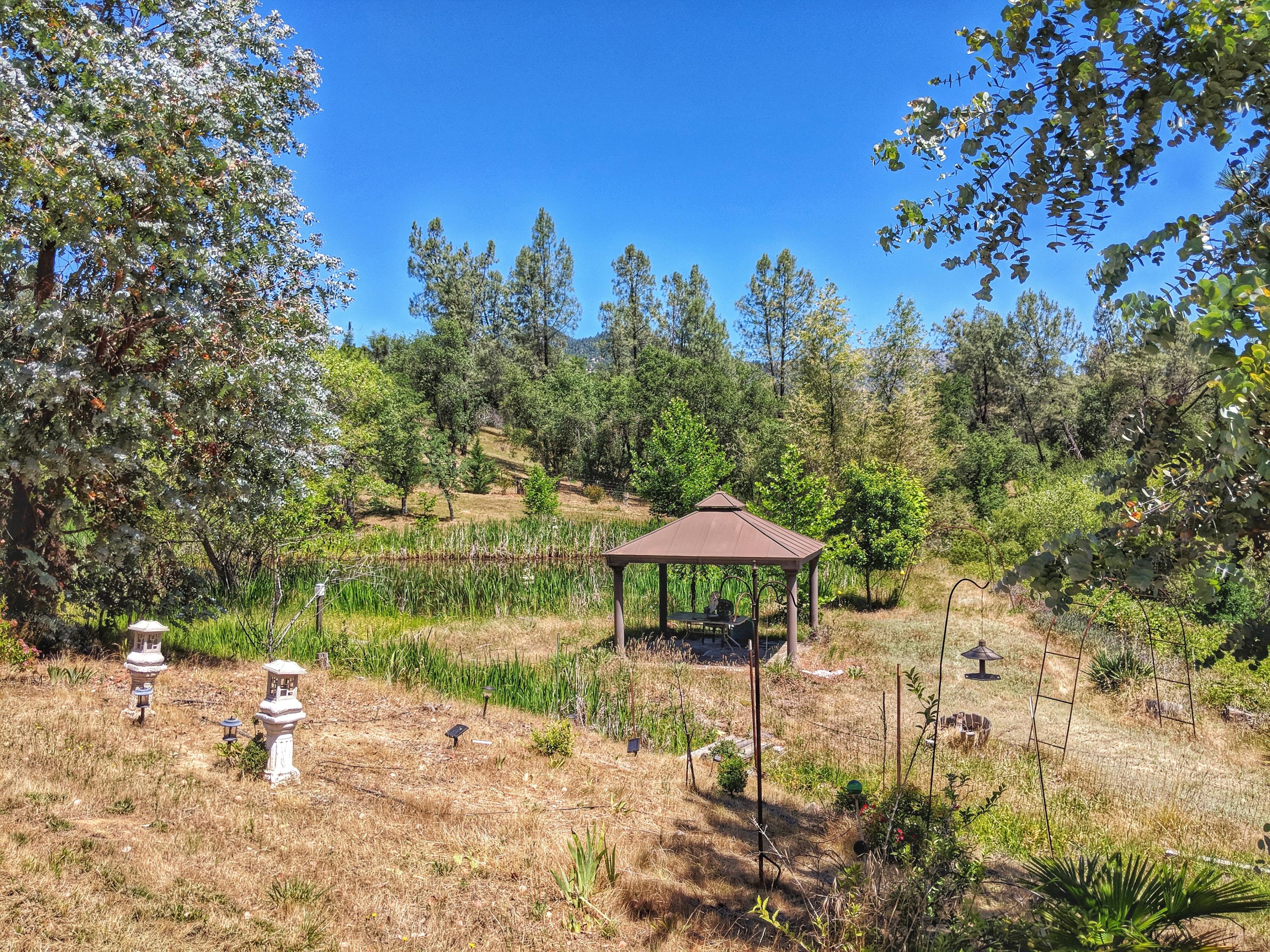 6818 Rector Creek Road Igo, CA 96047 - Photo 34 of 34 a view of a lake with a table and chairs under an umbrella