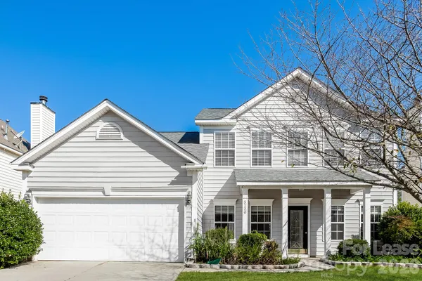a view of a white house next to a yard