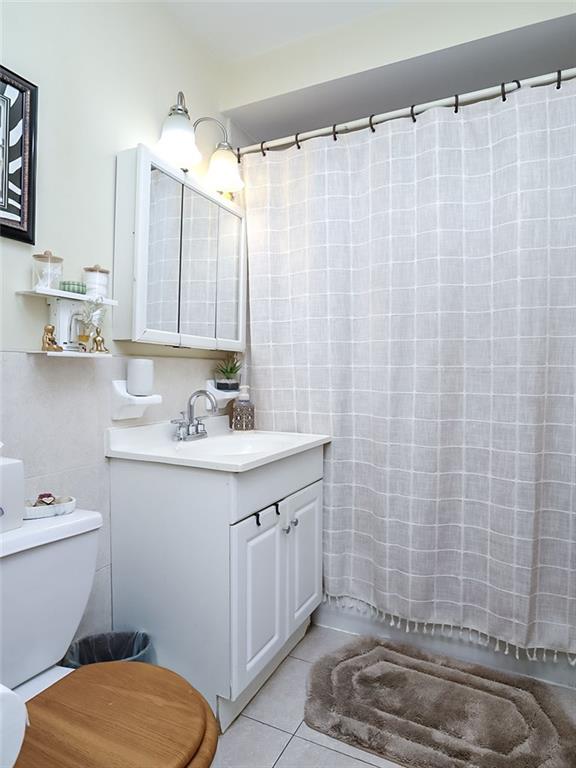 2312 Stuart Street, Unit 2L Brooklyn, NY 11229 - Photo 17 of 24 a bathroom with a sink a toilet and shower curtain
