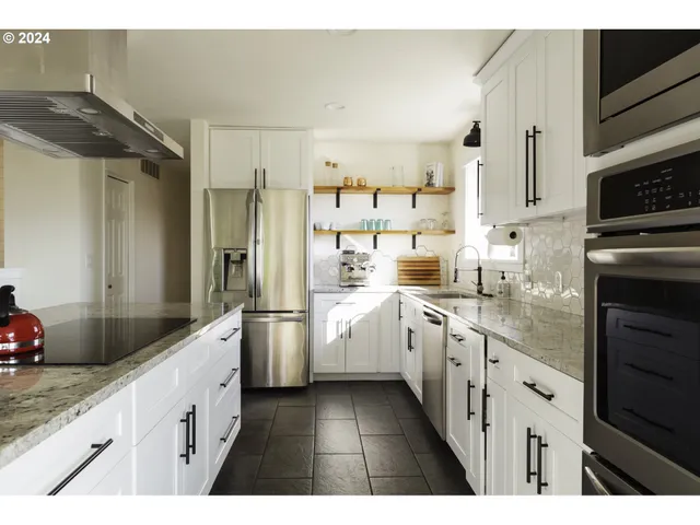 a kitchen with white cabinets and stainless steel appliances