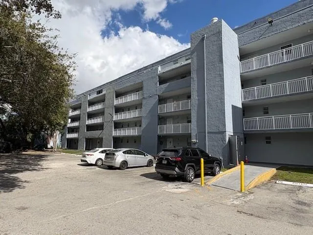 a view of building with cars parked in front of it