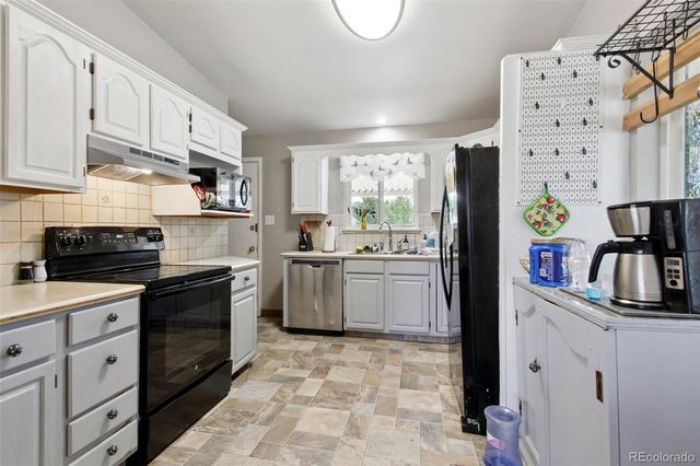 a kitchen with stainless steel appliances a refrigerator sink and cabinets