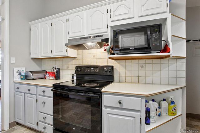 a kitchen with microwave cabinets and stove top oven