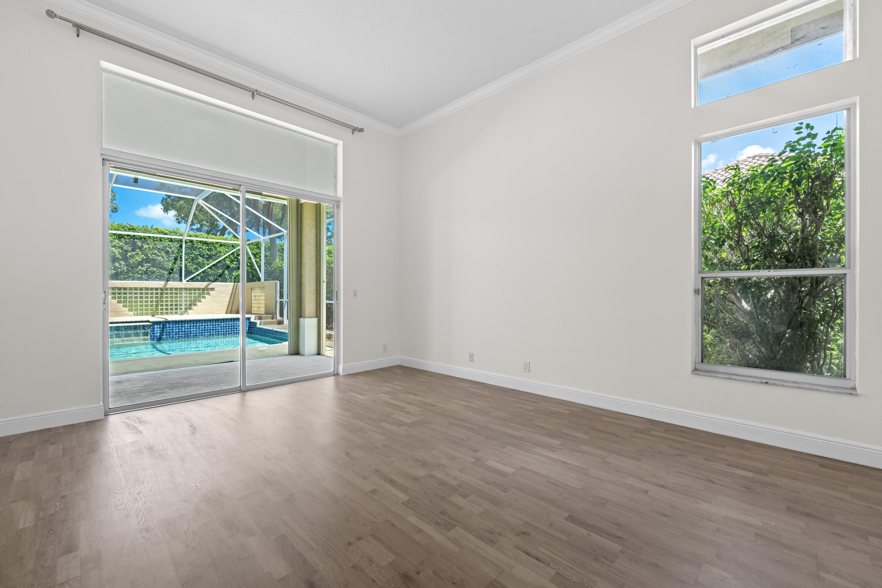 10648 Maple Chase Drive Boca Raton, FL 33498 - Photo 17 of 52 a view of an empty room with wooden floor and a window