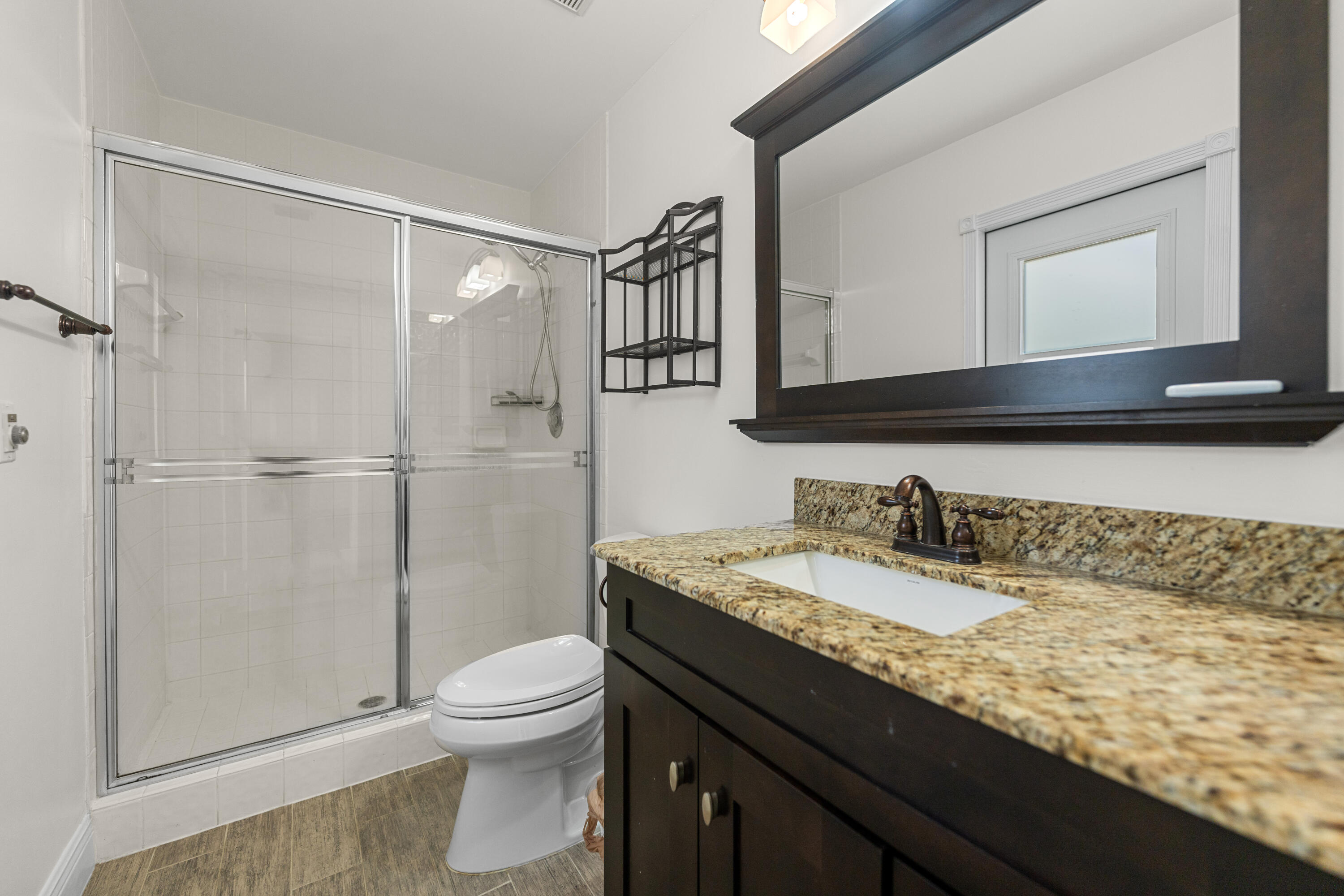 10648 Maple Chase Drive Boca Raton, FL 33498 - Photo 29 of 52 a bathroom with a granite countertop sink toilet a mirror and shower
