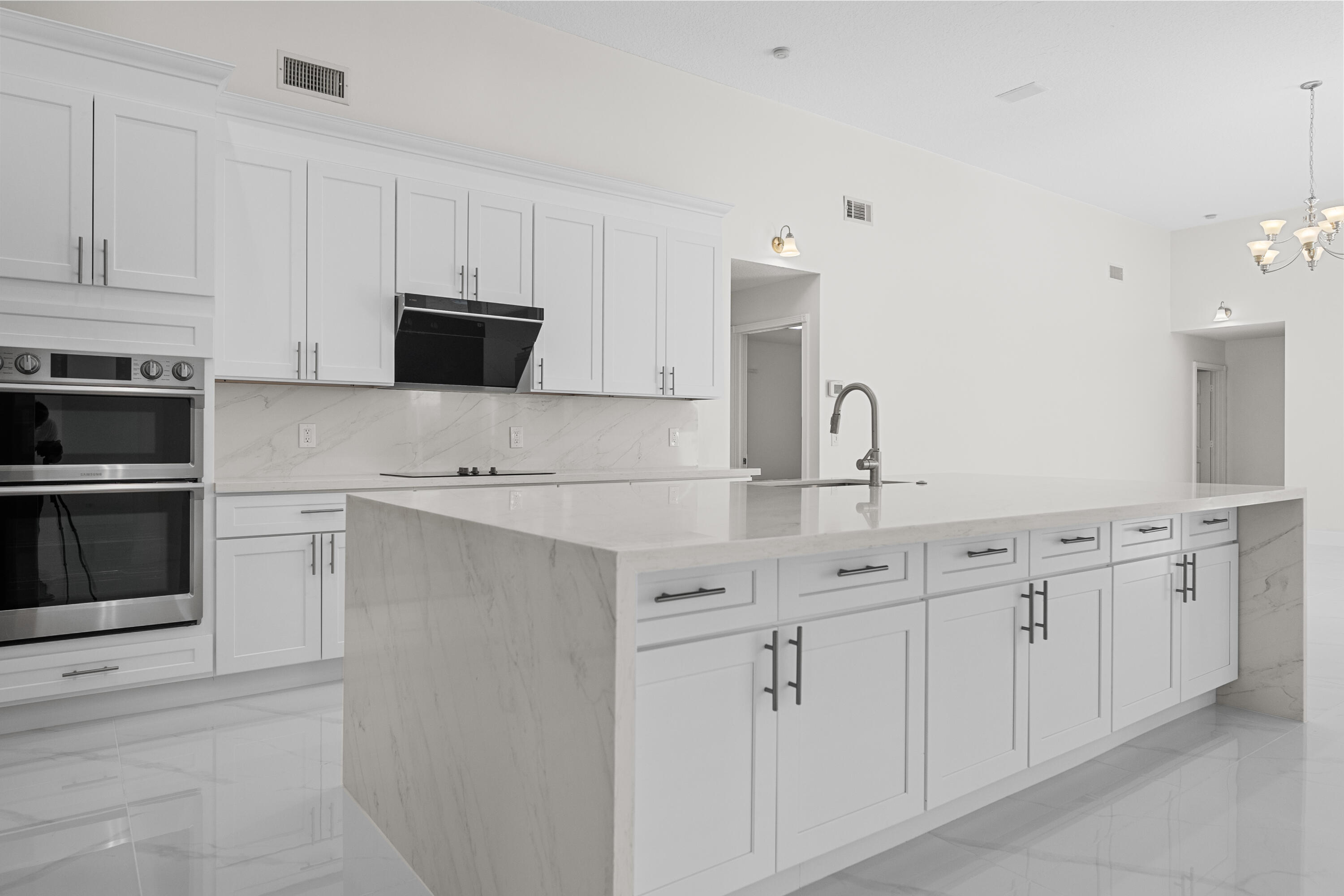 10648 Maple Chase Drive Boca Raton, FL 33498 - Photo 5 of 52 a kitchen with white cabinets and stainless steel appliances