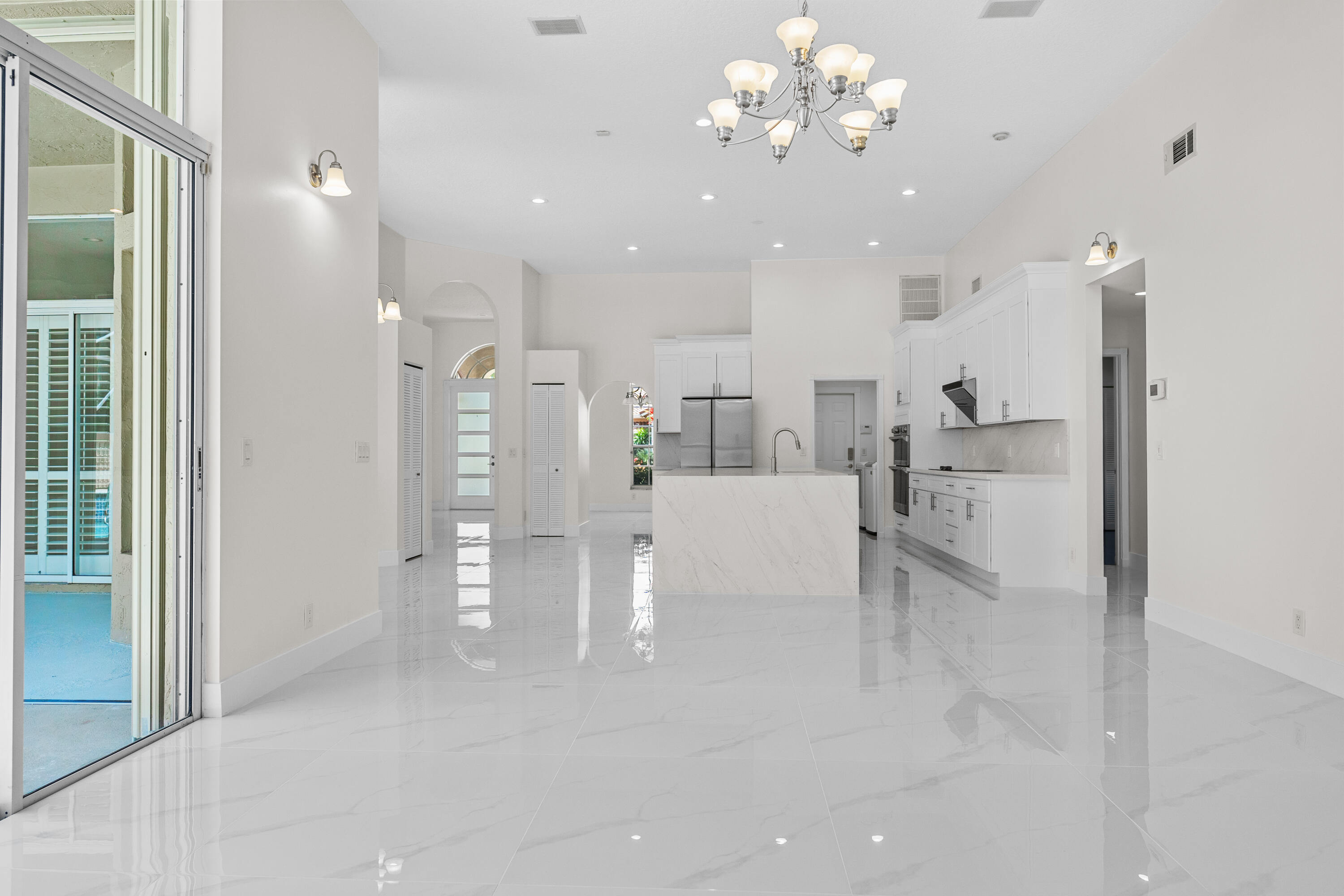 10648 Maple Chase Drive Boca Raton, FL 33498 - Photo 10 of 52 a view of a hallway with chandelier