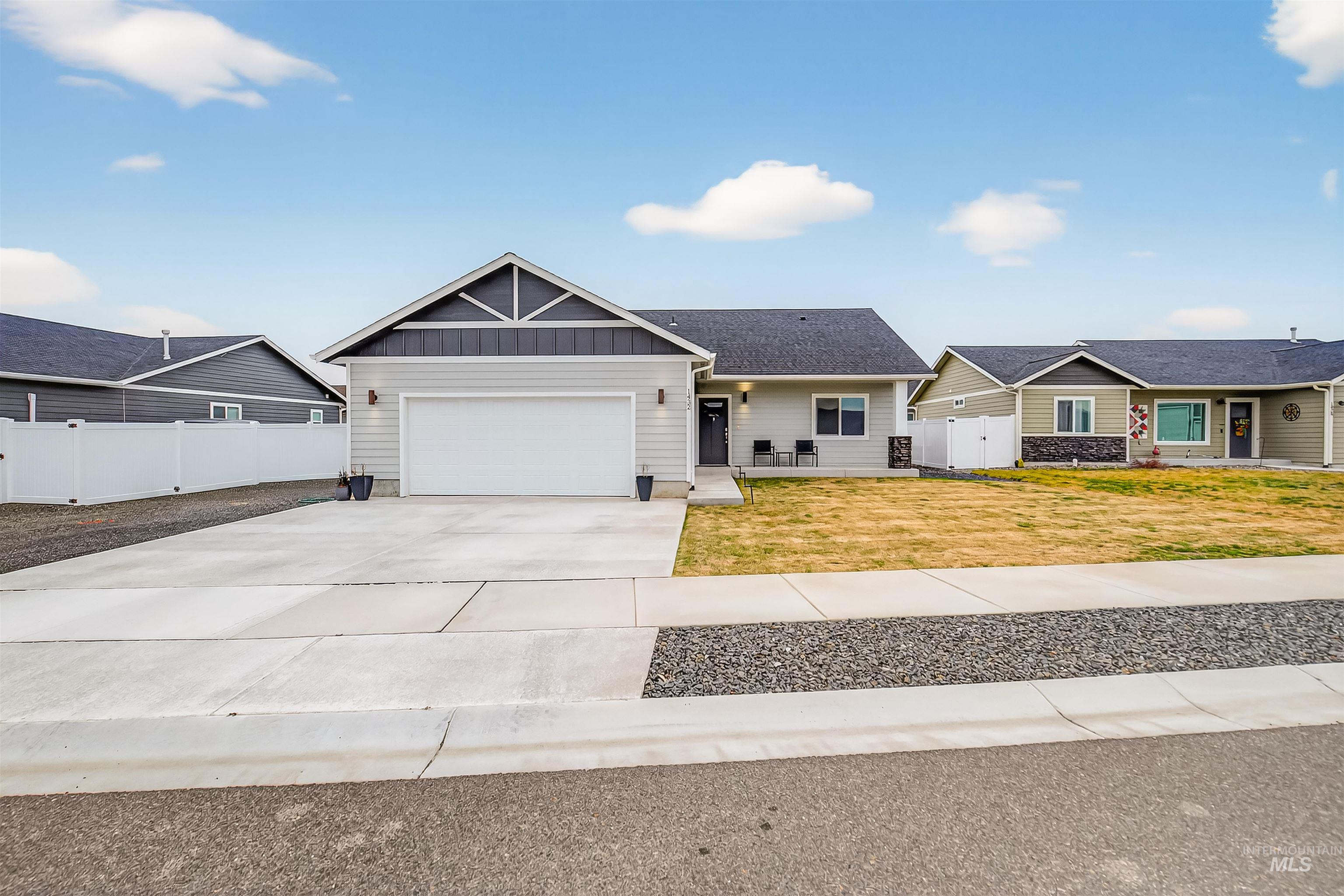View of front of home with board and batten siding, concrete driveway, and a garage