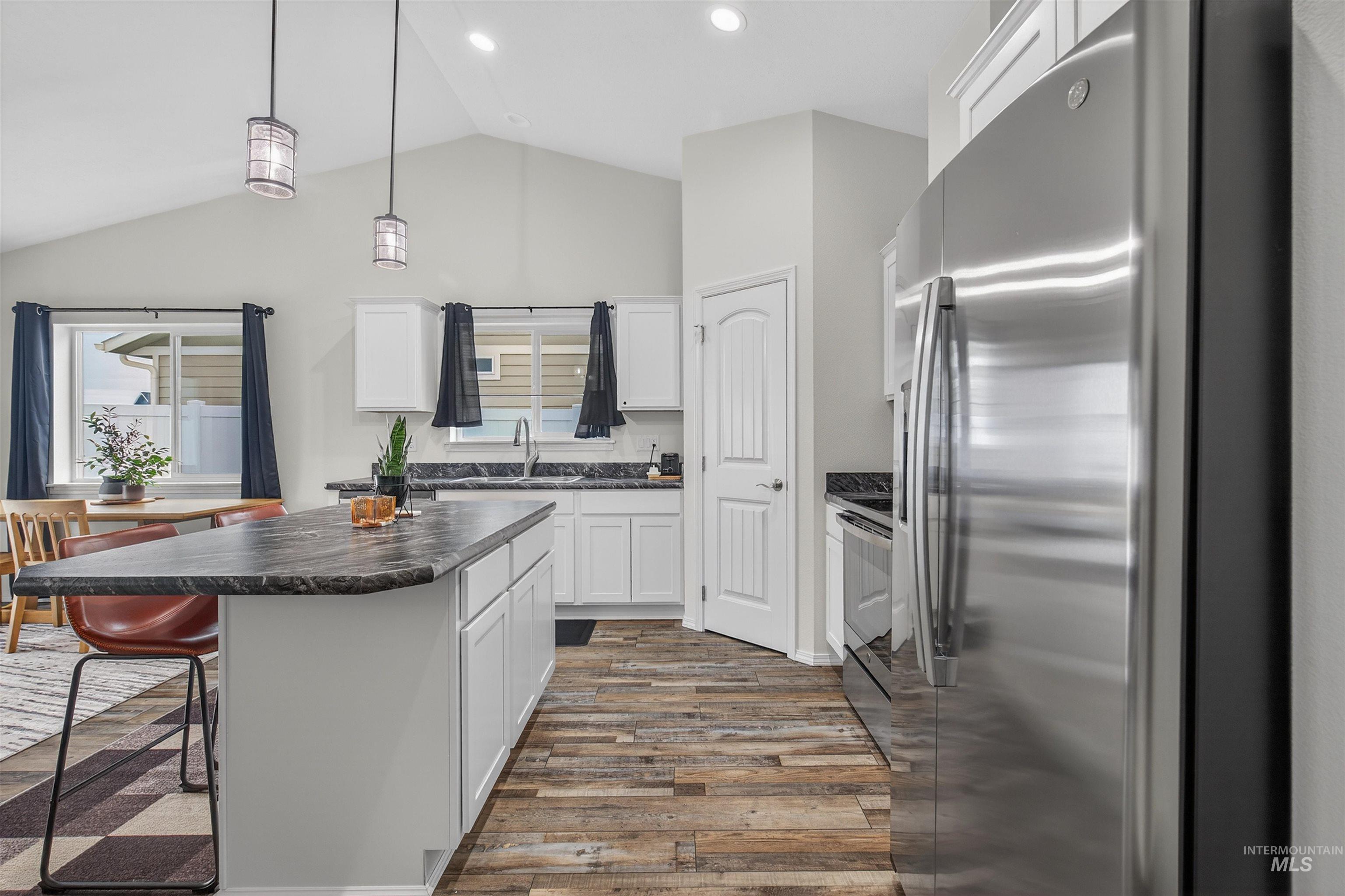 1432 Horizon Court Lewiston, ID 83501 - Photo 10 of 26 Kitchen with stainless steel appliances, white cabinetry, dark countertops, a kitchen bar, and pendant lighting