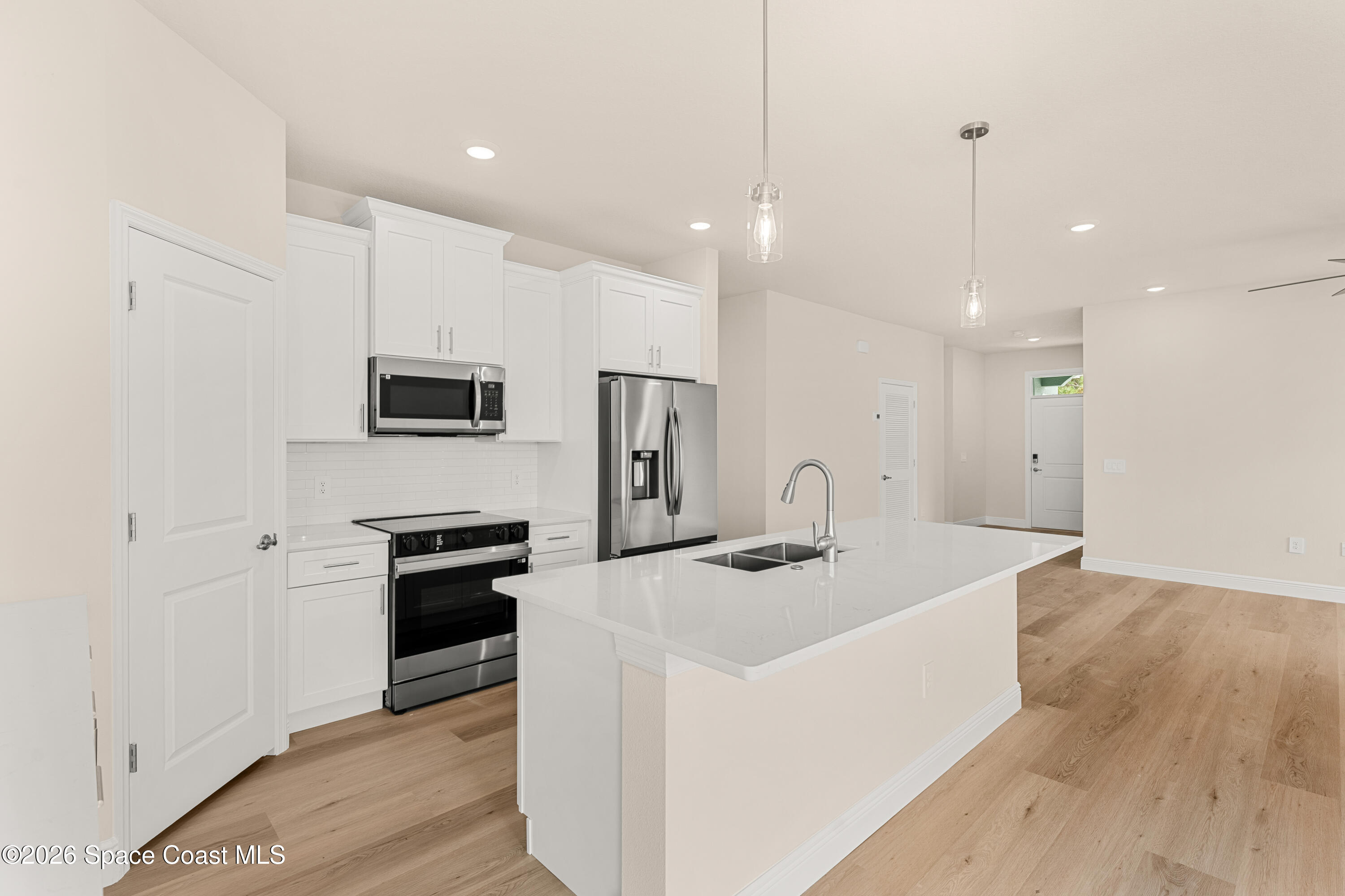 455 Mimosa Street Southwest Palm Bay, FL 32908 - Photo 11 of 43 a kitchen with stainless steel appliances granite countertop a sink a stove a refrigerator and a oven with wooden floor