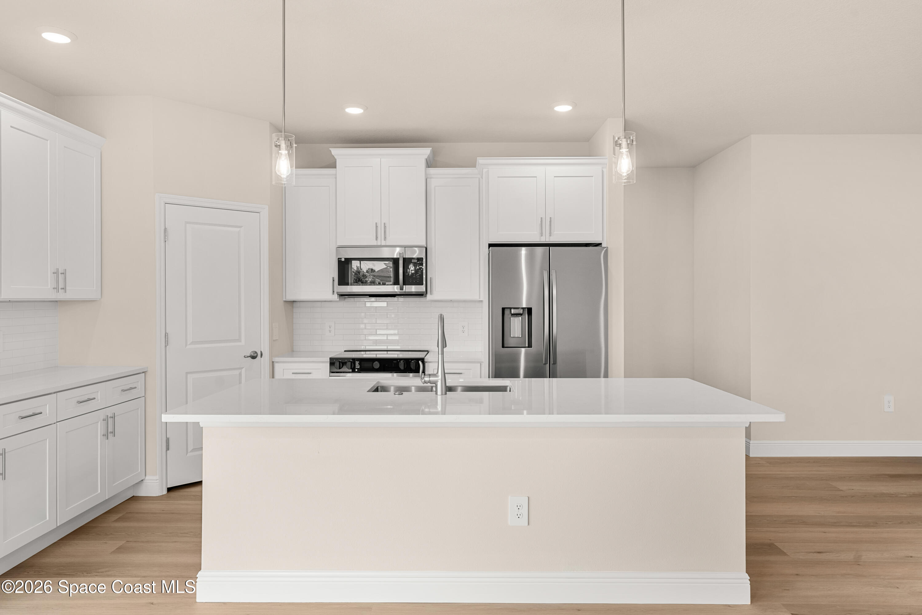 455 Mimosa Street Southwest Palm Bay, FL 32908 - Photo 12 of 43 a kitchen with stainless steel appliances a refrigerator a stove sink and white cabinets