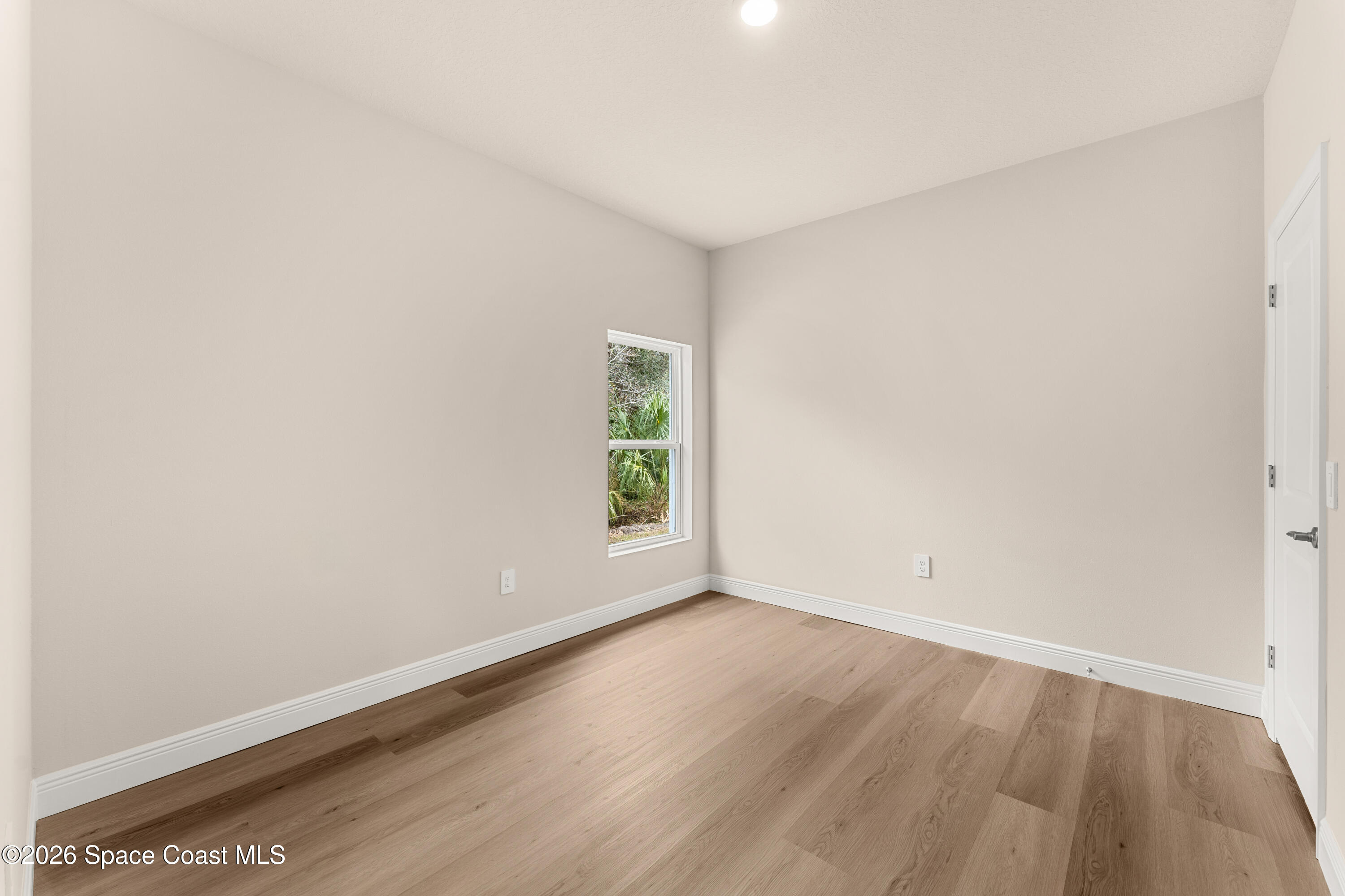 455 Mimosa Street Southwest Palm Bay, FL 32908 - Photo 15 of 43 an empty room with wooden floor and window