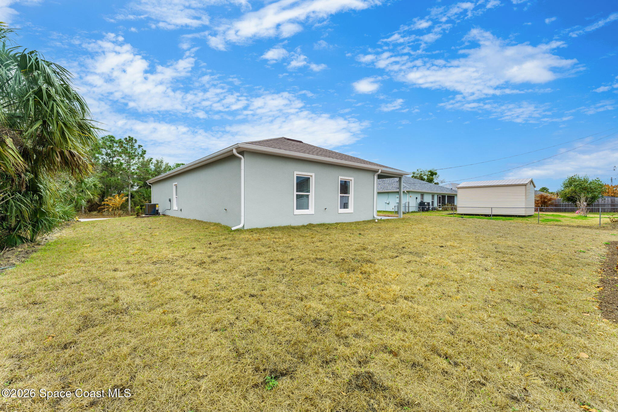 455 Mimosa Street Southwest Palm Bay, FL 32908 - Photo 22 of 43 a big white house with a large tree next to a yard