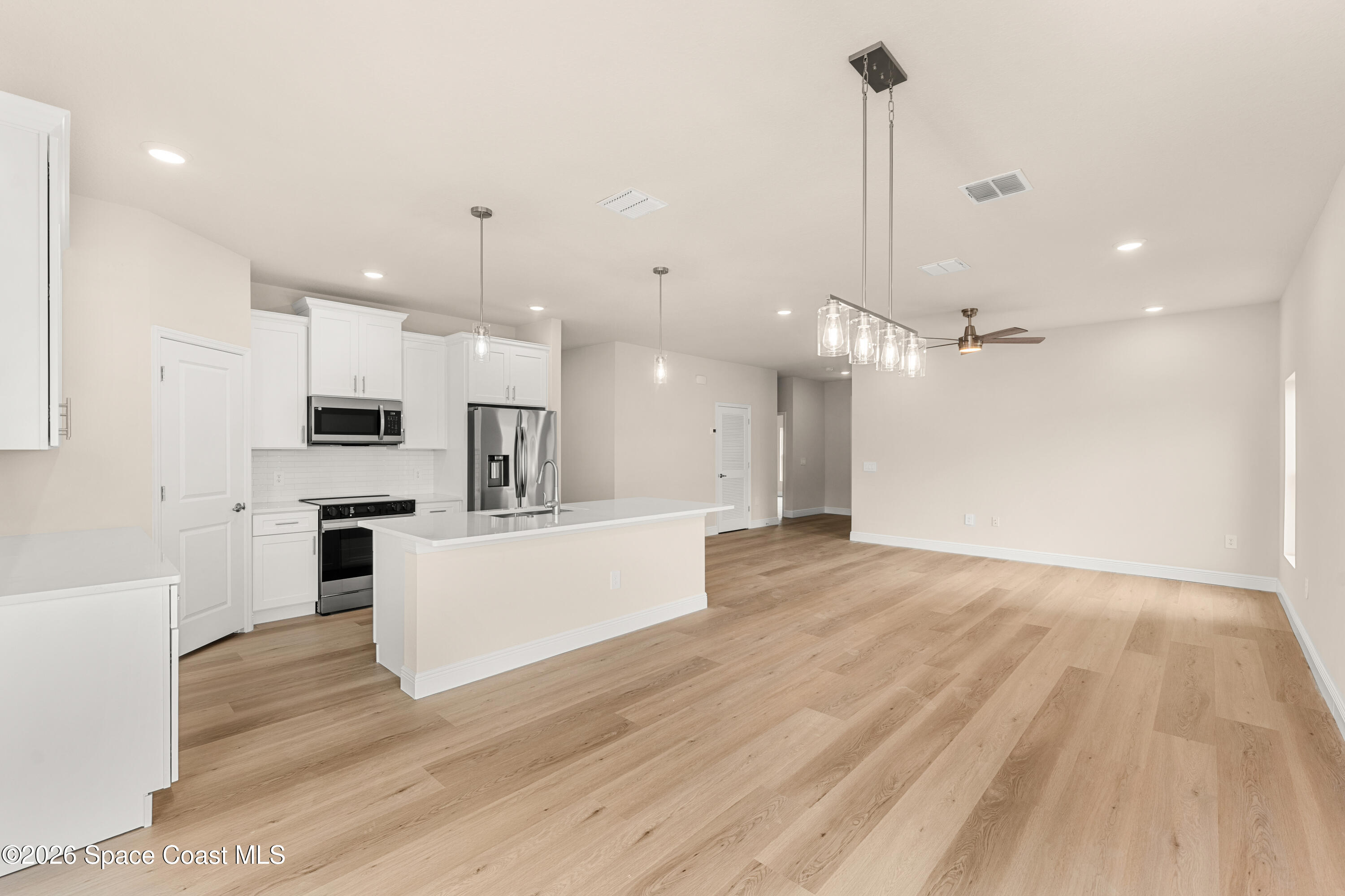 455 Mimosa Street Southwest Palm Bay, FL 32908 - Photo 10 of 43 a view of a kitchen with kitchen island a counter top space a sink and appliances