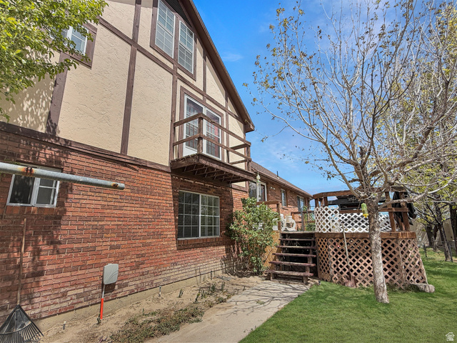 1716 Sagewood Road Price, UT 84501 - Photo 48 of 73 View of side of property featuring a balcony, a yard, a wooden deck, brick siding, and stucco siding