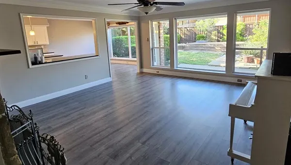 a view of a livingroom with wooden floor and a large window with outer view