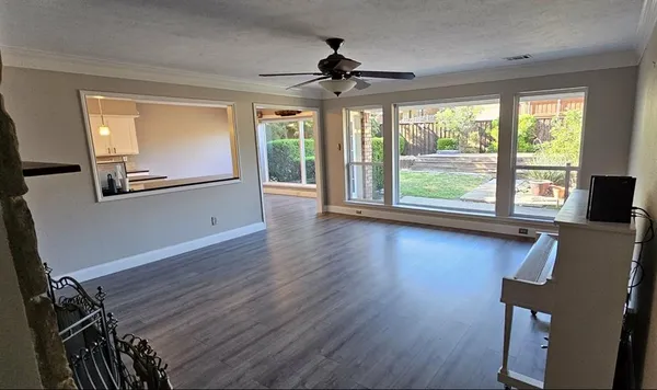 a view of a livingroom with wooden floor and a large window
