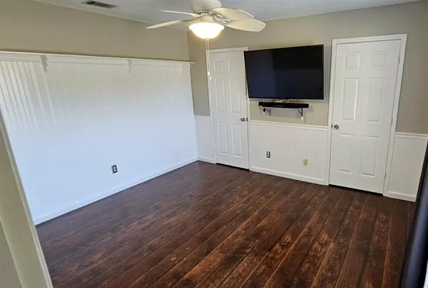 a view of room with wooden floor and flat screen tv
