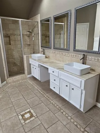 a bathroom with a double vanity sink mirror and shower