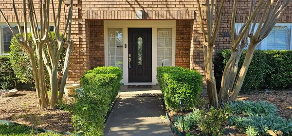 a front view of a house with a yard and fountain