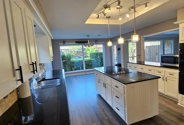a kitchen with stainless steel appliances granite countertop a sink stove and wooden floor