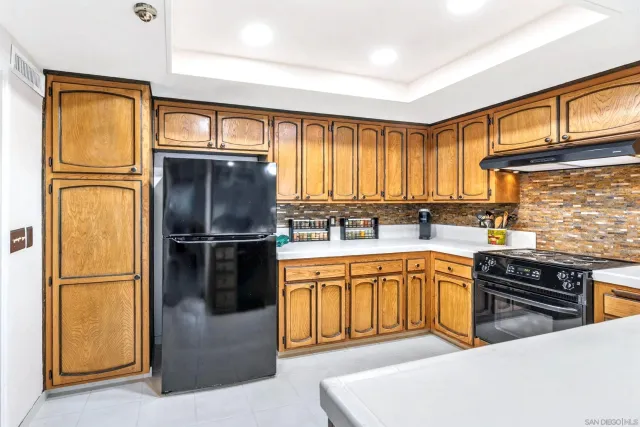 a kitchen with stainless steel appliances granite countertop a refrigerator a stove and a sink with cabinets