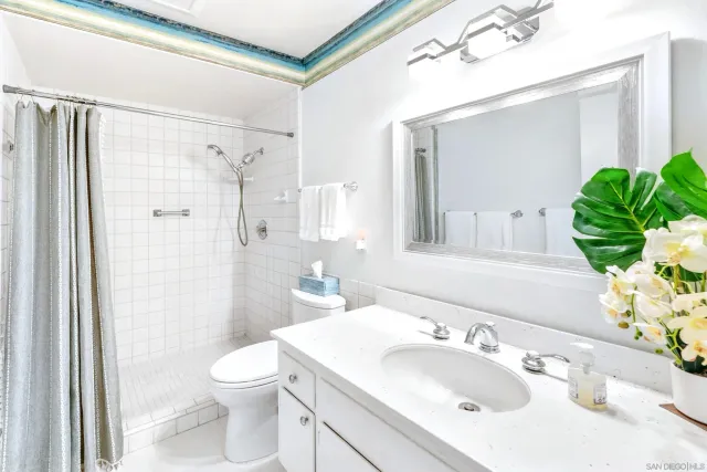 a bathroom with a sink vanity mirror and toilet