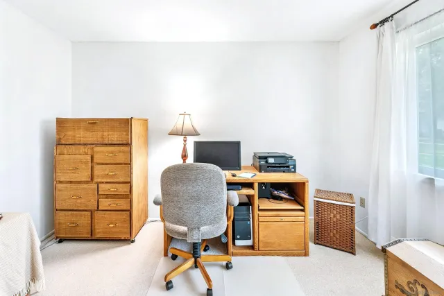 a bedroom with a bed and teddy bear on bed