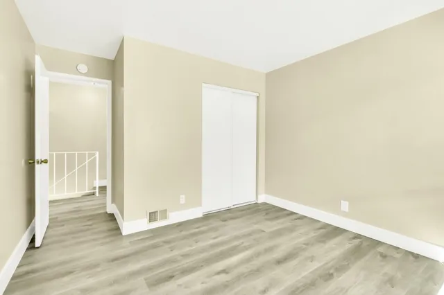 an empty room with wooden floor and a window