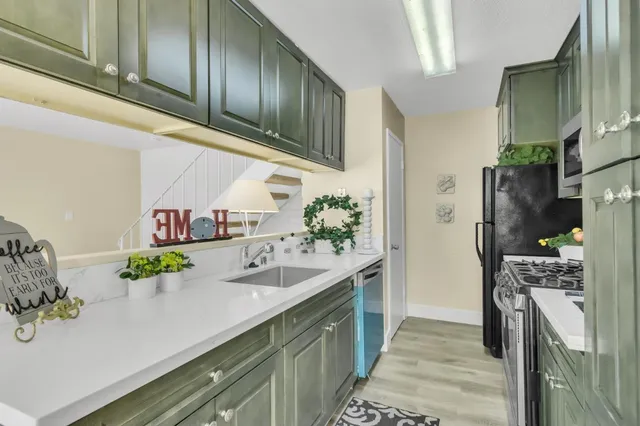 a kitchen with stainless steel appliances kitchen island granite countertop a refrigerator and a sink