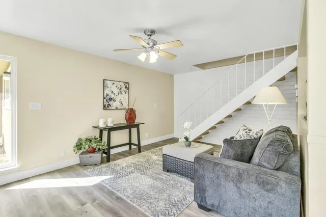 a living room with furniture and a ceiling fan