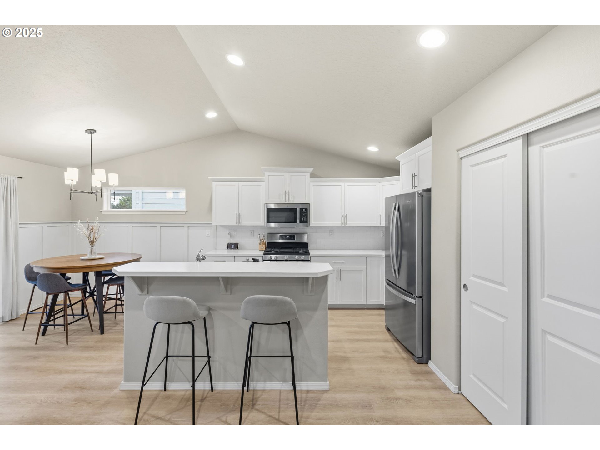 4970 Squirrel Street Springfield, OR 97478 - Photo 9 of 43 a kitchen with stainless steel appliances a refrigerator a stove a sink a dining table and chairs