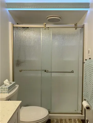 a bathroom with a shower a toilet and a sink