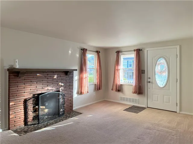 a living room with furniture a fireplace and a large window