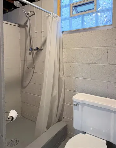 a white toilet sitting next to a shower