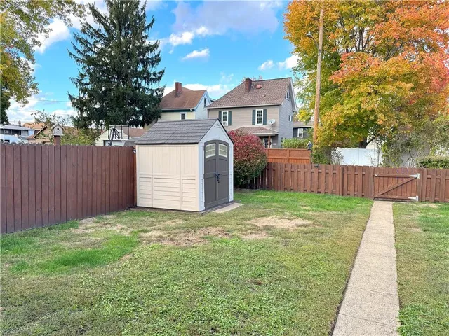 a view of a backyard with a garden and tree