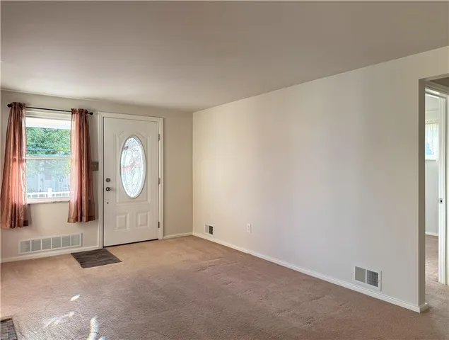 a view of a livingroom with wooden floor and window