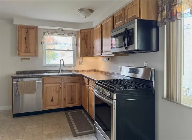 a kitchen with stainless steel appliances granite countertop a sink stove and microwave
