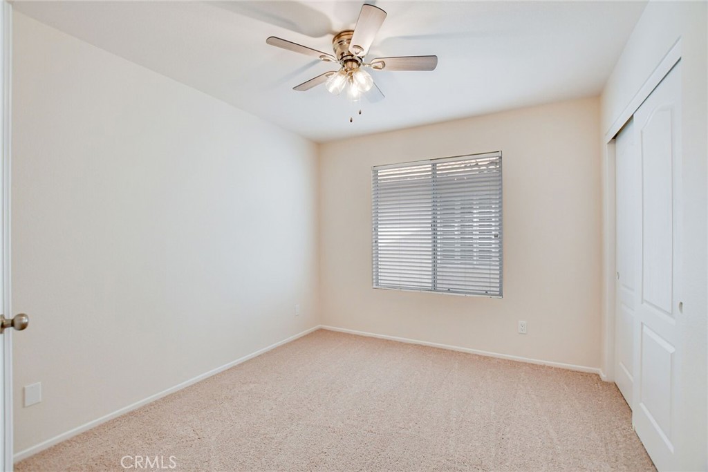 2787 Banyan Tree Lane Hemet, CA 92545 - Photo 27 of 36 an empty room with a chandelier fan and windows