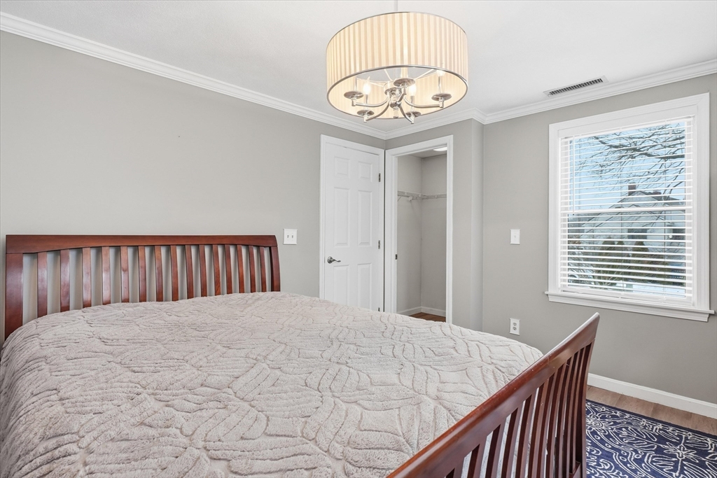 18 Carriage Court, Unit 18 Merrimac, MA 01860 - Photo 19 of 38 a view of a bedroom with a chandelier