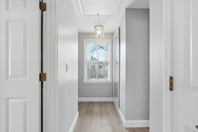 a view of a hallway with wooden floor and cabinet